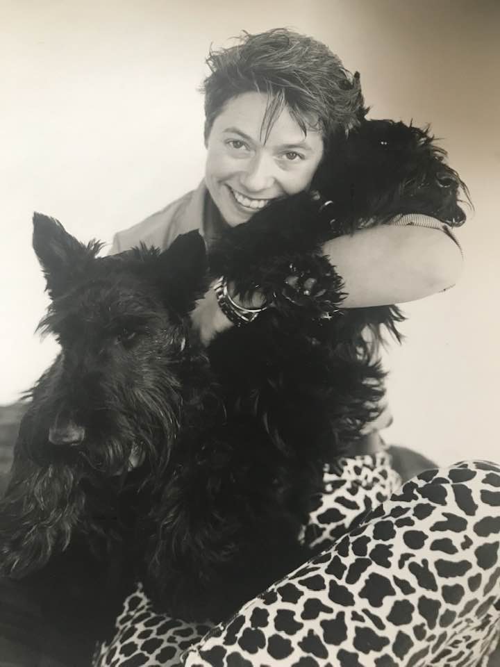Holly Adam holding two large-ish black Scottish Terriers