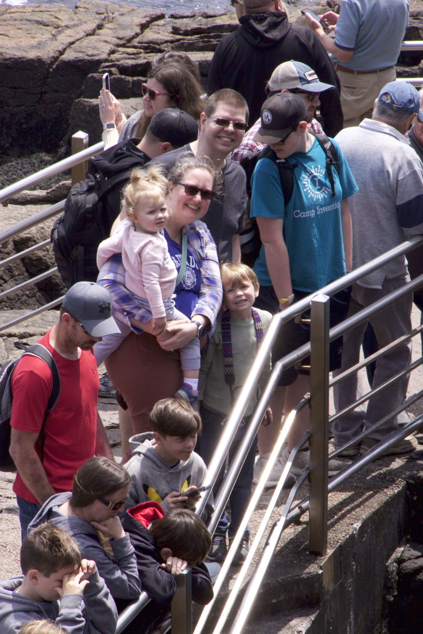 A crowd (that includes Josiah, Laura, Thomas, and Lydia) within the railings at Thunder Hole